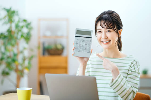 電卓をもってる笑顔の女性